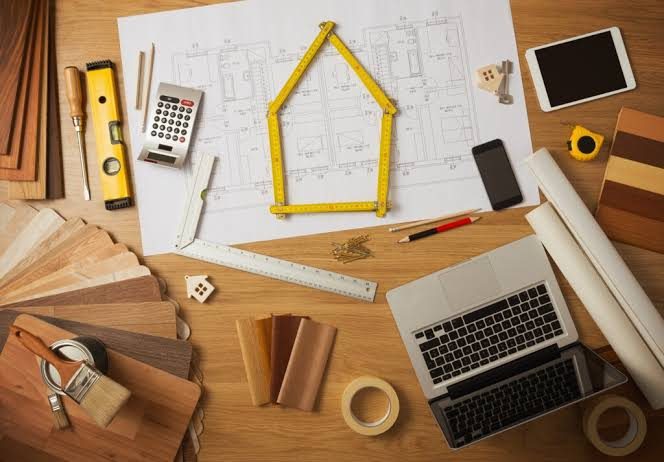 Home renovation plans, timber samples and tools on a workbench